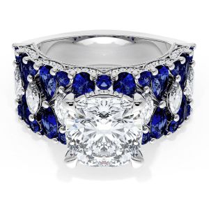 21CU9BS312W top view, cushion center stone above a wide white gold band of blue sapphires with marquise and pear diamond accents