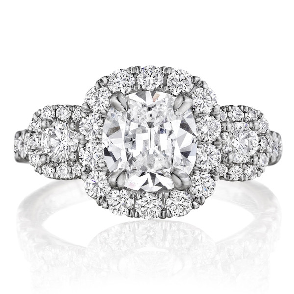 Henri Daussi ACMB white gold diamond engagement ring, front view of a cushion center in a halo between two haloed round side stones