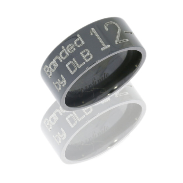 Lashbrook Z9F-DUCKBAND zirconium wedding band, angled view of a flat glossy black face engraved with waterfowl leg tag lettering and an interior inscription