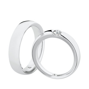 Christian Bauer 241600 18 karat white gold diamond wedding band, angled view of a polished flat face with square edges and a round stone tension set in a diagonal slot, shown with its matching ring
