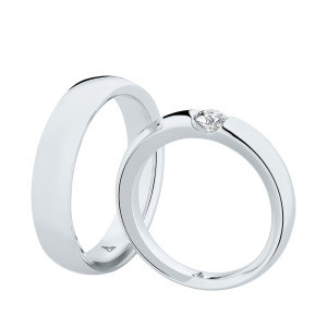 Christian Bauer 241600 platinum diamond wedding band, angled view of a polished flat face with square edges and a round stone tension set in a diagonal slot, shown with its matching ring