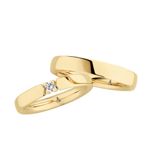 Christian Bauer 241689 18 karat yellow gold diamond wedding band, angled view of a polished flat face whose open ends hold one round stone in four small prongs, shown with its matching ring