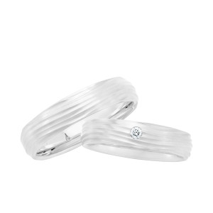 Christian Bauer 241732 18 karat white gold diamond wedding band, angled view of a matte surface cut with irregular wave grooves and one round stone flush set on top, shown with its matching ring