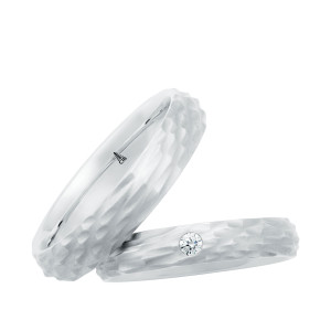 Christian Bauer 241736 platinum diamond wedding band, angled view of a matte hammered facet surface softly domed with one round stone flush set on top, shown with its matching ring