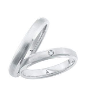 Christian Bauer 241737 platinum diamond wedding band, angled view of a brushed satin center between narrow polished beveled edges with one small flush set stone, shown with its matching ring