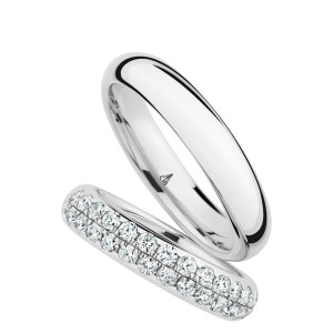 Christian Bauer 246948 18 karat white gold diamond wedding band, angled view of a polished rounded profile fully set with two staggered rows of round stones in shared prongs, shown with its matching ring