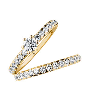 Christian Bauer 246950 14 karat yellow gold diamond wedding band, angled view of a polished rounded profile set all the way around with round stones in scalloped shared prongs, shown with its matching ring