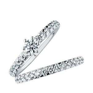 Christian Bauer 246950 platinum diamond wedding band, angled view of a polished rounded profile set all the way around with round stones in scalloped shared prongs, shown with its matching ring