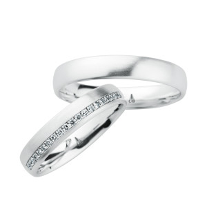 Christian Bauer 246961 14 karat white gold diamond wedding band, angled view of a satin dome with a channel set line of tiny stones along one edge halfway around, shown with its matching ring