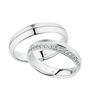 Christian Bauer 247042 14 karat white gold diamond wedding band, angled view of a brushed flat face with a milgrain edged row of small bead set stones along one side, shown with its matching ring