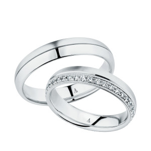Christian Bauer 247042 platinum diamond wedding band, angled view of a brushed flat face with a milgrain edged row of small bead set stones along one side, shown with its matching ring