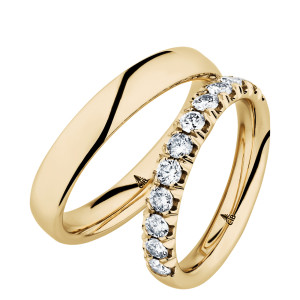 Christian Bauer 247050 14 karat yellow gold diamond wedding band, angled view of a polished rounded profile with a half row of prominent round stones in scalloped shared prongs, shown with its matching ring