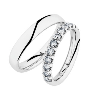 Christian Bauer 247050 18 karat white gold diamond wedding band, angled view of a polished rounded profile with a half row of prominent round stones in scalloped shared prongs, shown with its matching ring