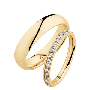 Christian Bauer 247064 18 karat yellow gold diamond wedding band, angled view of a softly rounded profile with a continuous row of small bead set stones between polished edges, shown with its matching ring