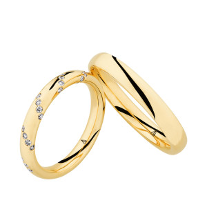 Christian Bauer 247083 18 karat yellow gold diamond wedding band, angled view of a polished rounded profile scattered with small flush set stones in loose diagonal clusters, shown with its matching ring