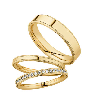 Christian Bauer 247095 18 karat yellow gold diamond wedding band, angled view of a flat profile with a continuous row of tiny bead set stones between two milgrain rails, shown with its matching rings