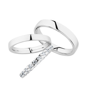 Christian Bauer 247099 18 karat white gold diamond wedding band, angled view of a rounded profile fully set with larger round stones in shared prongs meeting edge to edge, shown with its matching ring