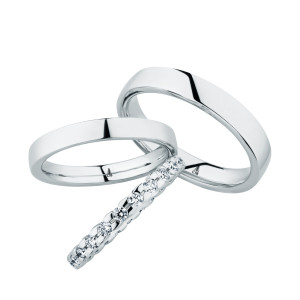 Christian Bauer 247099 platinum diamond wedding band, angled view of a rounded profile fully set with larger round stones in shared prongs meeting edge to edge, shown with its matching rings