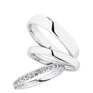 Christian Bauer 247100 14 karat white gold diamond wedding band, angled view of a rounded profile with round stones in shared prongs running around the full circumference, shown with its matching rings