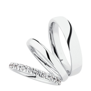 Christian Bauer 247106 14 karat white gold diamond wedding band, angled view of a rounded profile with evenly spaced round stones in shared prongs around the whole circumference, shown with its matching rings