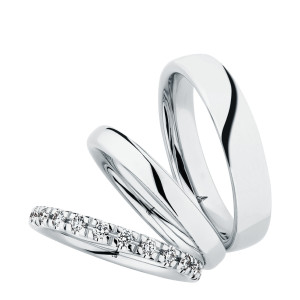 Christian Bauer 247106 platinum diamond wedding band, angled view of a rounded profile with evenly spaced round stones in shared prongs around the whole circumference, shown with its matching rings