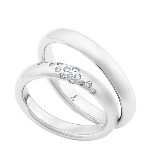 Christian Bauer 247110 14 karat white gold diamond wedding band, angled view of a matte domed profile with a scattered diagonal cluster of small flush set stones, shown with its matching ring