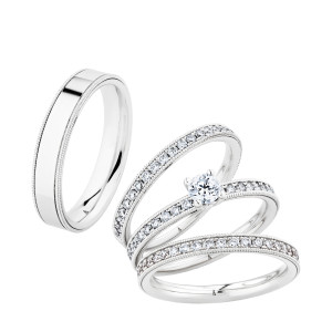 Christian Bauer 274451 18 karat white gold wedding band, angled view of a flat mirror polished face bordered on both edges by fine milgrain beading and a polished step, shown with its matching rings