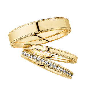Christian Bauer 274451 18 karat yellow gold wedding band, angled view of a flat mirror polished face bordered on both edges by fine milgrain beading and a polished step, shown with its matching rings
