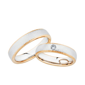 Christian Bauer 274465 two-tone platinum and 18 karat gold wedding band, angled view of a finely hammered white domed center edged by narrow polished rose rims over a polished interior, shown with its matching ring