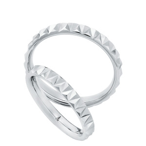 Christian Bauer 274802 platinum wedding band, angled view of a bright polished surface cut into a continuous row of raised pyramid facets around the outside, shown with its matching ring