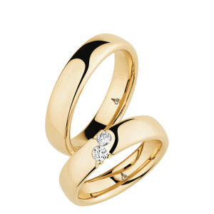 Christian Bauer 280103 14 karat yellow gold wedding band, angled view of a mirror polished softly domed face with a sharp edge break into the polished interior, shown with its matching ring