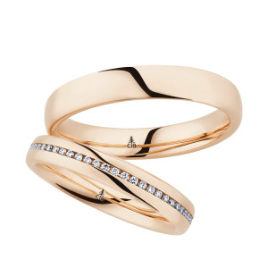 Christian Bauer 280193 14 karat rose gold wedding band, angled view of a rounded polished dome, the bright surface running unbroken into a polished interior, shown with its matching ring