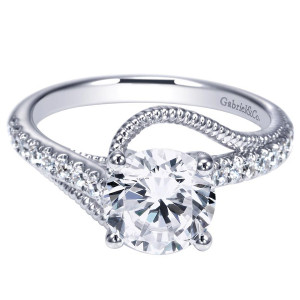 Gabriel & Co. ER9043W44JJ 14 karat white gold Contemporary engagement ring, top view of the pave arm sweeping across the round center in a bypass crossing