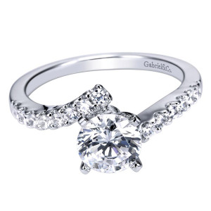 Gabriel & Co. ER4249W44JJ 14 karat white gold Contemporary engagement ring, angled view of a round center set between two shared prong rows that sweep past each other