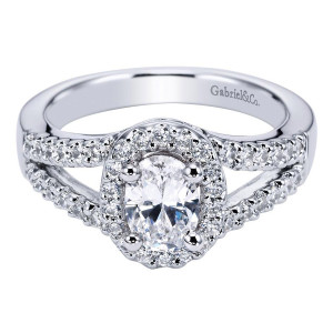 Gabriel & Co. ER5866W44JJ 14 karat white gold Contemporary engagement ring, angled top view of the oval center in a single halo above crossing pave rails