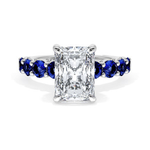 415RAD95X7BS Platinum top view, radiant cut center stone on a white metal band lined with round blue sapphires