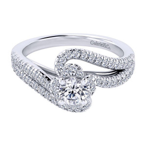 Gabriel & Co. ER910142W44JJ 14 karat white gold Contemporary engagement ring, angled view of the round center hugged by a curved pave swirl and bypassing arms