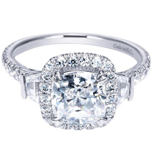 Gabriel & Co. ER9191W44JJ 14 karat white gold Contemporary engagement ring, front view of a cushion center haloed and flanked by step cut side stones over pave shoulders