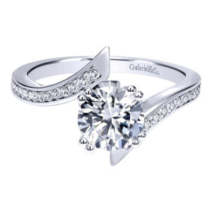 Gabriel & Co. ER11684R4W44JJ 14 karat white gold Contemporary engagement ring, front view of the round center gripped by paired prongs between two bypass rails of small stones