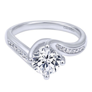 Gabriel & Co. ER10437W44JJ 14 karat white gold Contemporary engagement ring, front view of a round center crossed by two arms holding channel set rounds