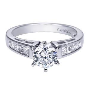 Gabriel & Co. ER1737W44JJ 14 karat white gold Contemporary engagement ring, angled view of the round center in six prongs above channel set square stones