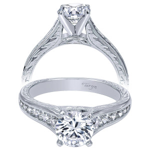 Taryn TE10118W44JJ 14 karat white gold engagement ring, front and profile views of a round center above channel set stones on hand engraved shoulders