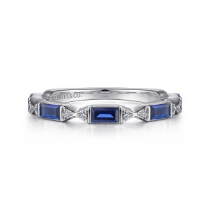 Gabriel & Co. AN15555W44SA 14 karat white gold Art Deco anniversary band, front view of a notched edge with blue baguette stones and small round diamonds between