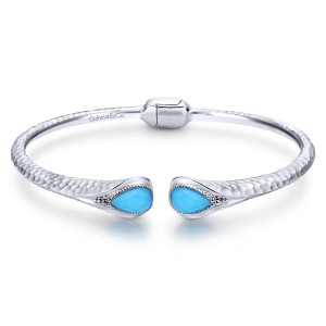 Gabriel & Co. BG3675SVJXT sterling silver Souviens bangle, front view of the hammered cuff, a blue pear shaped stone at each end and a plate behind