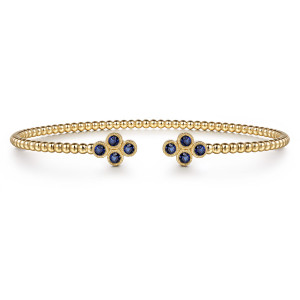 Gabriel & Co. BG4124-65Y4JSA 14 karat yellow gold Bujukan bangle, front view of the two blue stone clusters facing each other across the gap
