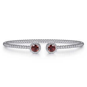 Gabriel & Co. BG4245-6W45GN 14 karat white gold Bujukan bangle, front view of two halo caps facing each other, each a red stone ringed by diamonds
