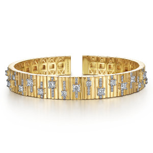 Gabriel & Co. BG4470-65Y84JJ 18 karat yellow gold Contemporary bangle, front view of staggered prong set diamonds with short tiny stone lines on grooved segments