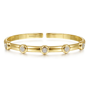 Gabriel & Co. BG4479-57Y45JJ 14 karat yellow gold Contemporary bangle, front view of round diamond stations between smooth segments above the flat inner strip and maker's mark