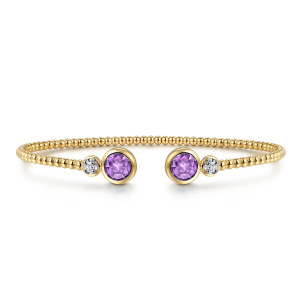 Gabriel & Co. BG4926-62M45AM 14 karat white and yellow gold Bujukan bangle, front view of the cuff with two purple stones facing across the gap and a tiny diamond beside each