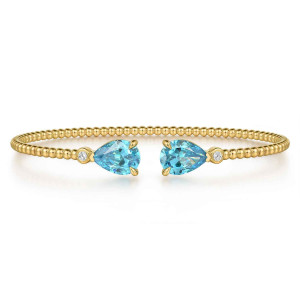Gabriel & Co. BG4928-57Y45BT 14 karat yellow gold Bujukan bangle, front view of the two blue pear stones with a small diamond beside each one